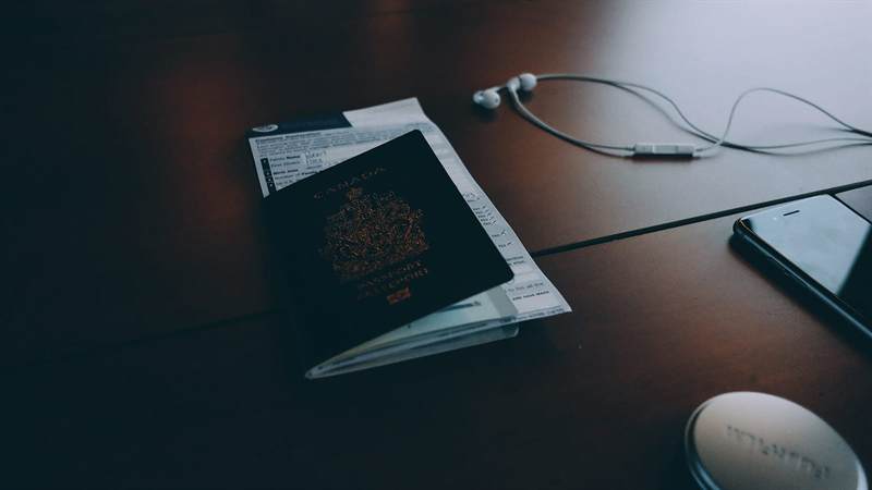 Passeport et documents de voyage sur un bureau en bois foncé
