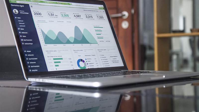 Laptop auf einem Schreibtisch mit Charts und Statistiken