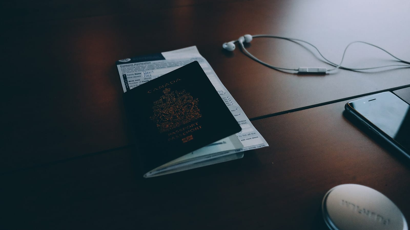 Passport and travel documents on a dark wooden desk